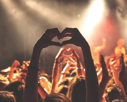 hands making a heart at a concert