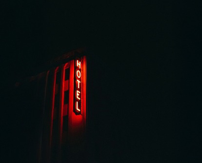 Red neon sign reading &quot;Hotel&quot; at night.