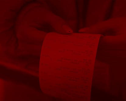 A close-up photo of hands holding a long grocery receipt.