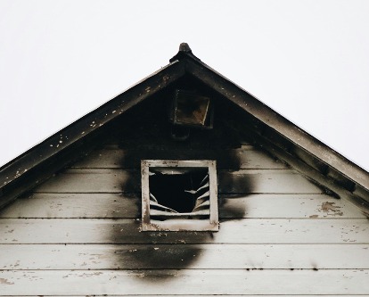 Attic window of a house with fire damage.