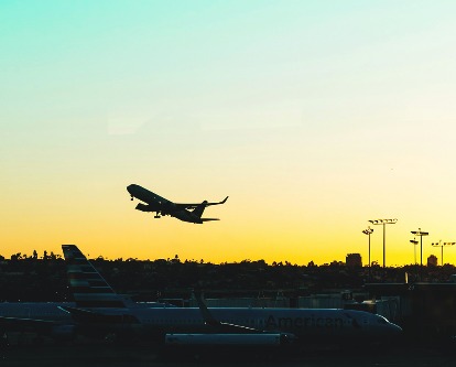 An airplane taking off at sunrise.