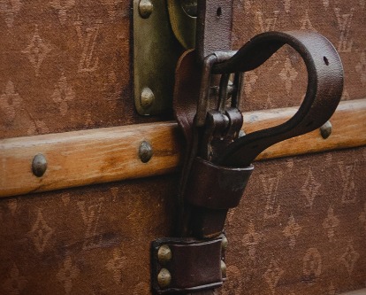 Close up of latch of a Louis Vuitton steamer trunk.