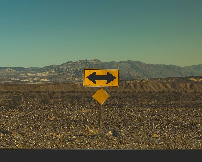 Roadside sign with arrows pointing in both directions.