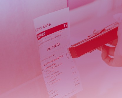 Hand stapling receipt for an Uber Eats delivery to a bag.