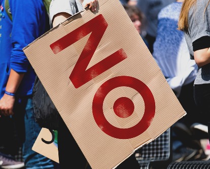 A protester holding a sign reading &quot;NO&quot; where the &quot;O&quot; is the Target logo.