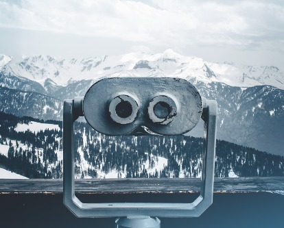 An observatory looking out over a snowy mountain range.