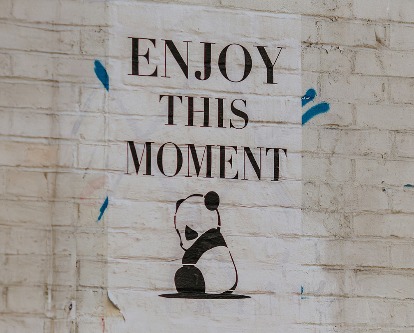 Poster reading &quot;Enjoy This Moment&quot; with illustration of a panda.