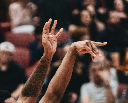 Follow through of man taking a shot in a basketball game.