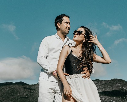 Color photograph of a two people on the bow of a boat on a sunny day.