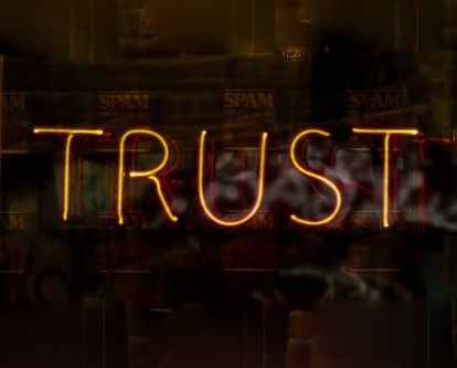 Color photograph of a neon sign reading "Trust".