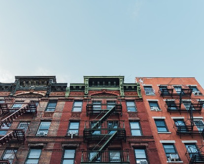 Color photograph looking up from the street at a group of New York apartment buildings.