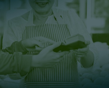 Two people completing a digital transaction in a grocery store.
