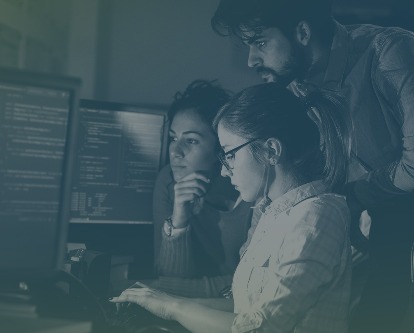 Three students working on a computer.