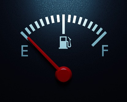 Fuel gauge with a red needle indicating empty.