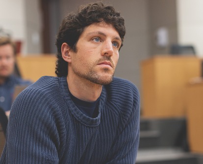 Color photograph of a USC Marshall student listening intently in class.