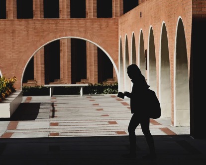 Silhouetted student walking on the USC campus.