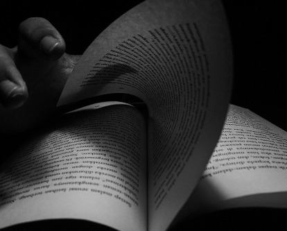 A hand turning the page of a book.