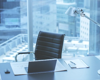 Color photograph of an empty office desk and chair.