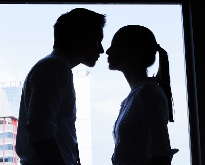 Two silhouetted people leaning in for a kiss.