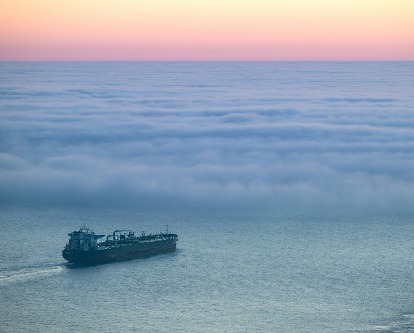 An oil tanker sailing into a fog bank.