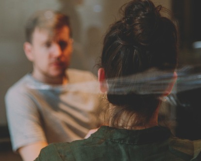 Looking through a window at a business meeting between two people in casual attire.