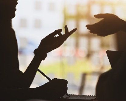A conversation where both people are using their hands to emphasize their points.