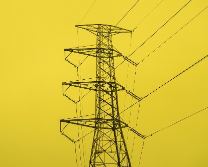 Yellow and black duotone photograph of an electrical tower.