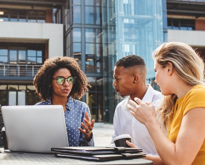 Four business professionals at an outdoor workshop.