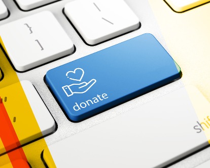 Color photograph of a computer keyboard with a blue key for "donate".
