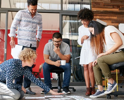 Color photograph of a team of five collaborating in a creative office setting.