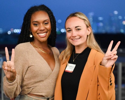 Two USC Marshall students flashing the 'Fight On!' sign.