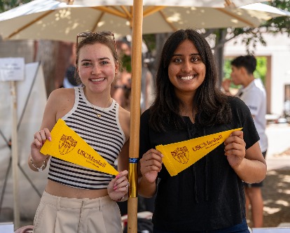 students holding USC Marshall pennants